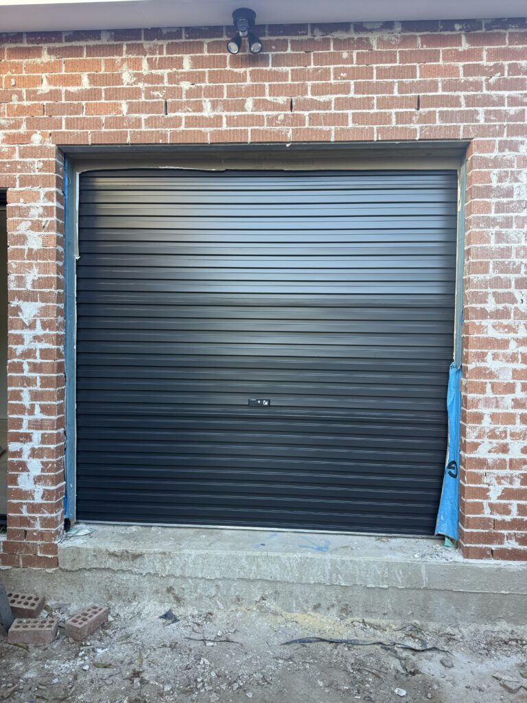a black garage door 2400 mm high × 2460 mm wide,